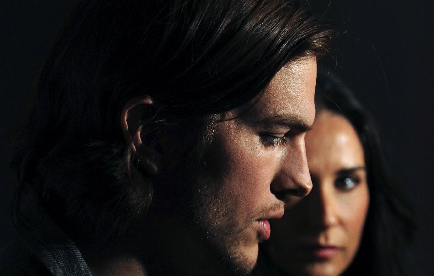 Close up of Ashton Kutcher and Demi Moore in shadows.