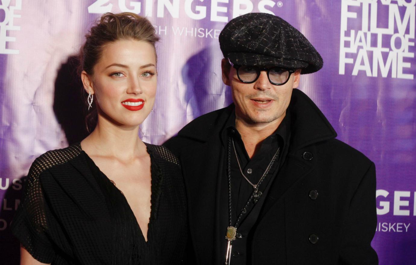 Johnny Depp looked dapper in a paperboy hat and a black winter coat over a black suit while Amber Heard wore a lacy black dress.