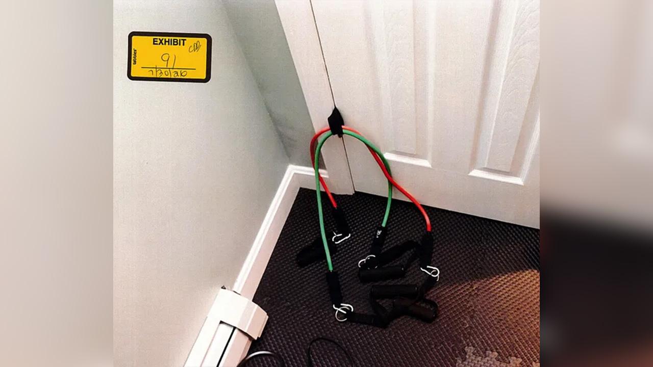 A red pair and green pair of exercise bands was attached to a door.