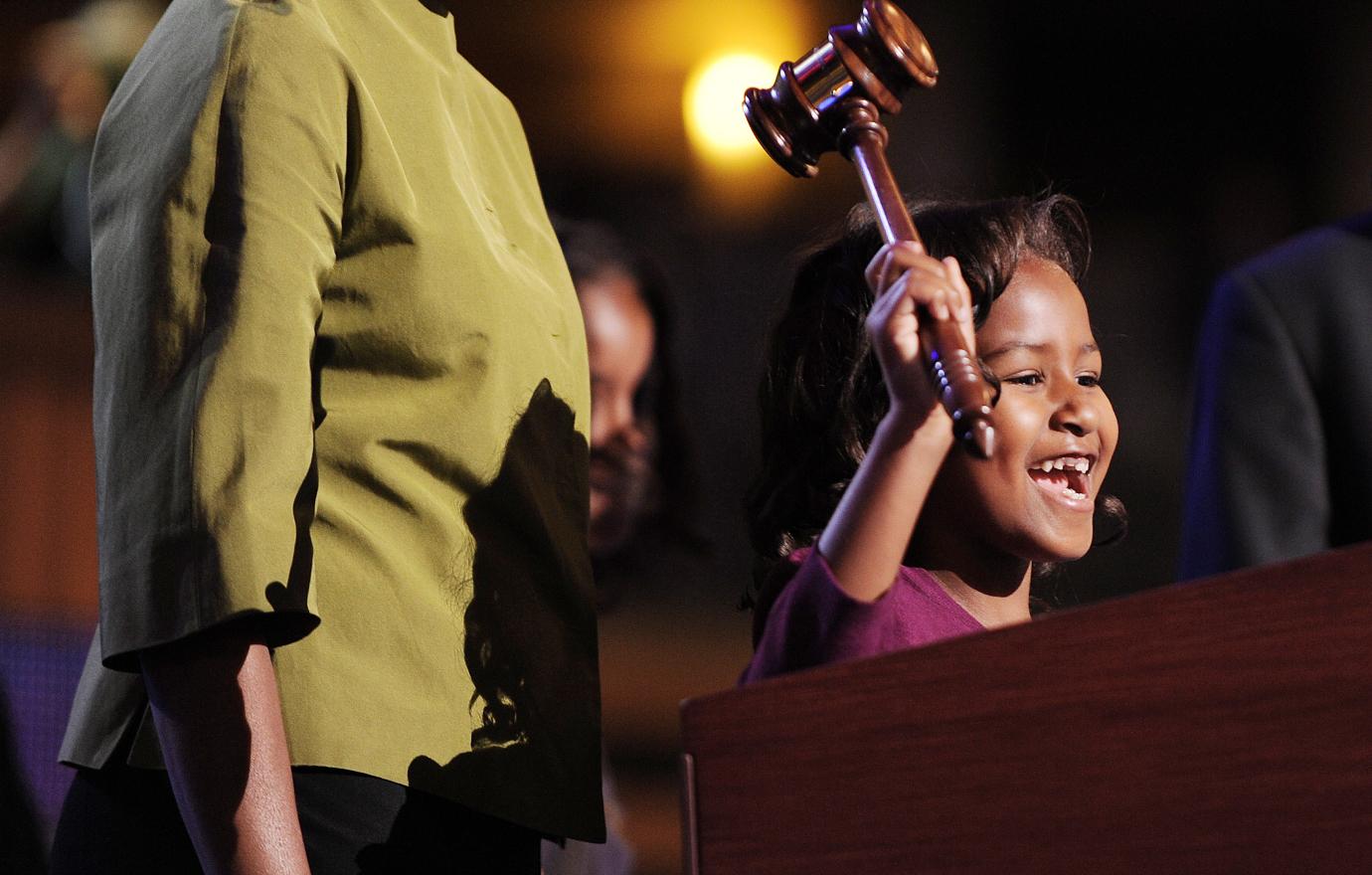 A young Sasha Obama holds a gavel and smiles