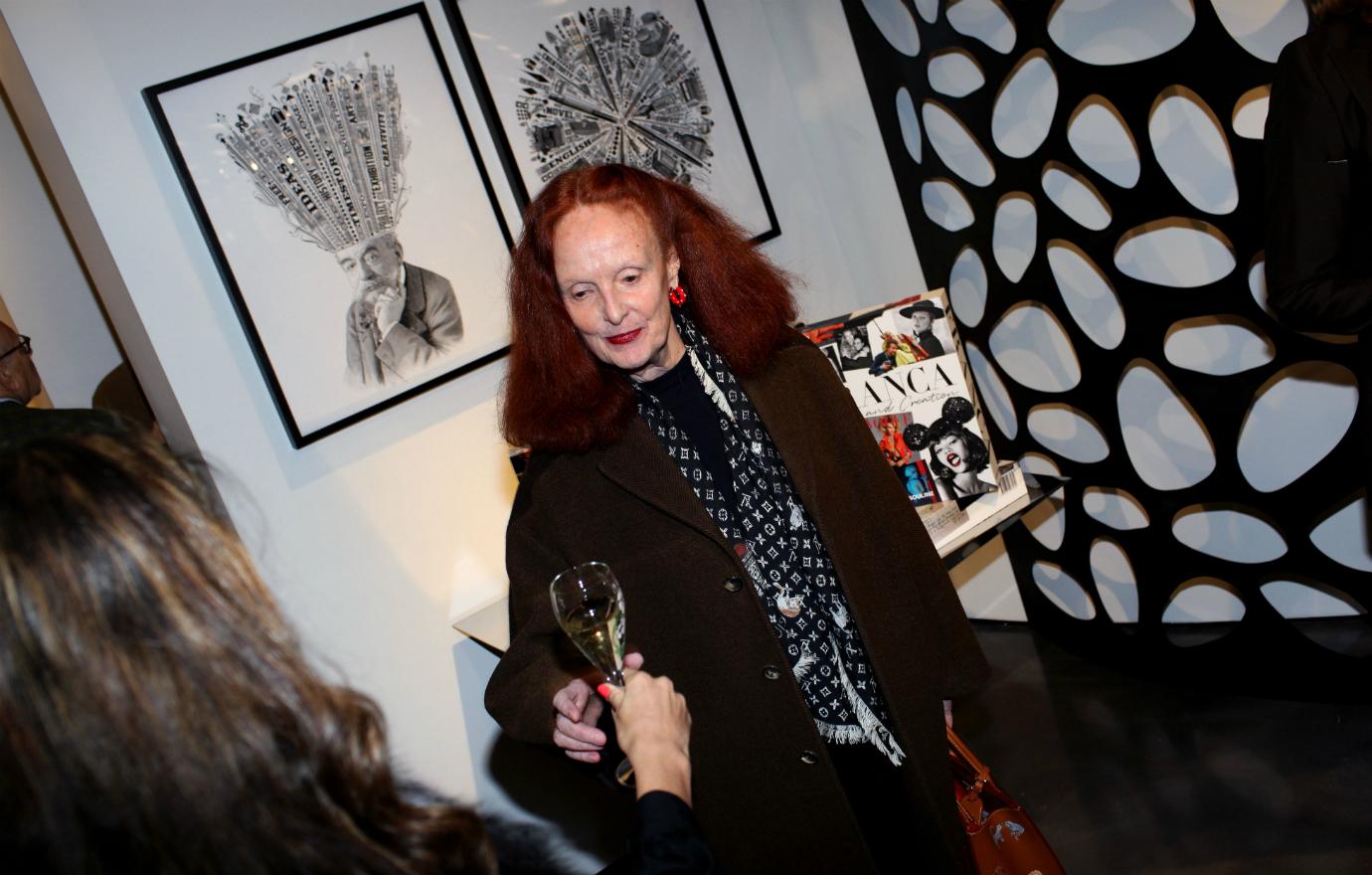 Grace Coddington raising a glass of wine.