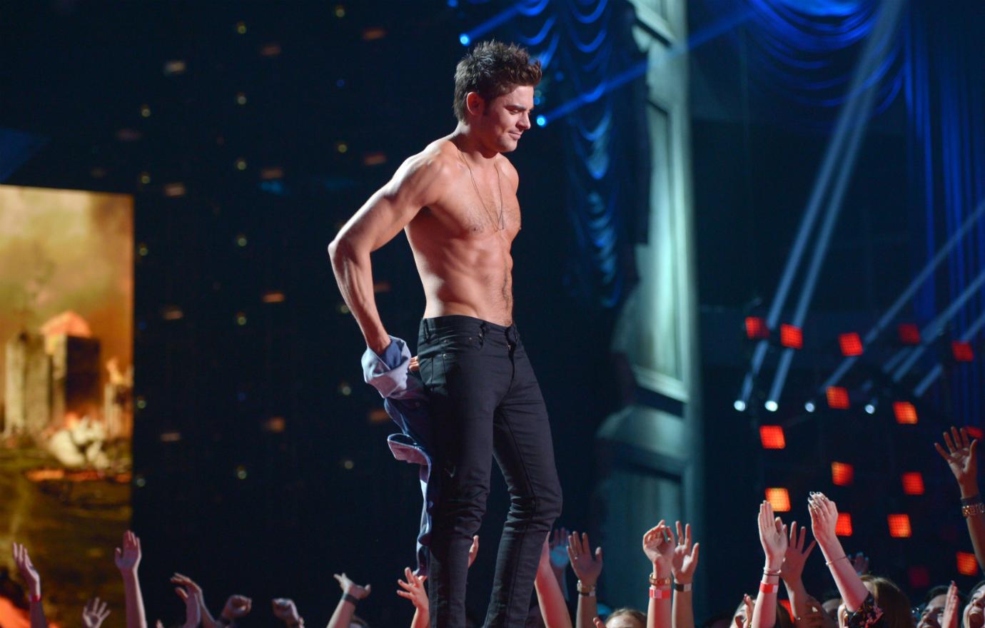 Zac Efron is shirtless on stage.