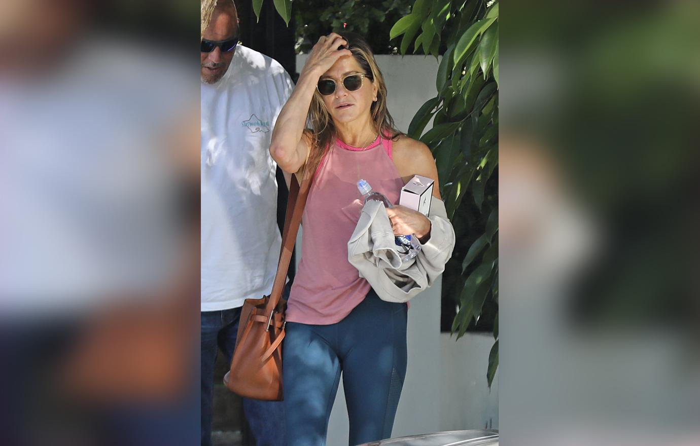 Jennifer Aniston Wearing Sunglasses Pink Tank Top and Navy Leggings Flaunts Body