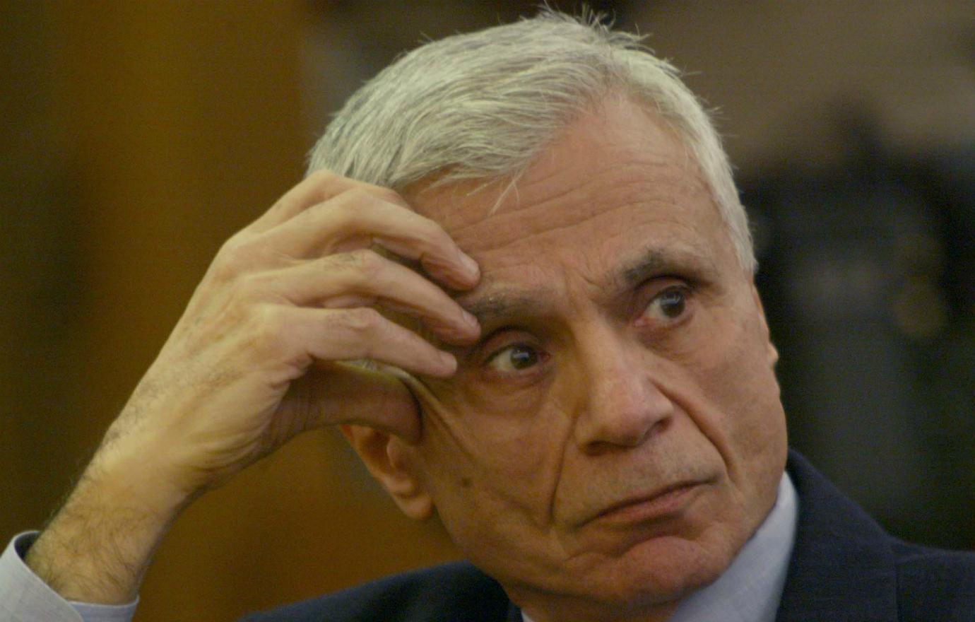 Robert Blake, with his hand on his temple, sits in court.