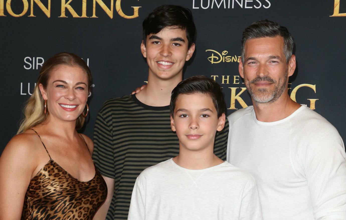 LeAnn Rimes, in a leopard print top, poses alongside Eddie Cibrian and their two kids on the red carpet.