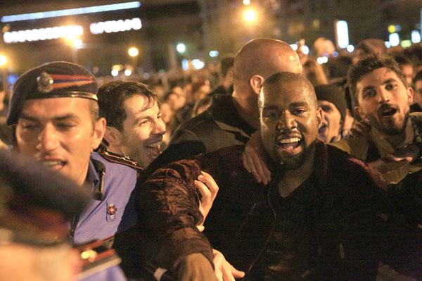 Kanye West jumps into water as fans, cops, jump in along with the soaking wet rapper at last minute concert in Armenia. Kanye decided to organize the show at literally 9pm on late Sunday night and by using social media over 3,000 screaming fans showed up at the duck pond to watch him perform at nearly 1:20am local time. Kanye was on stage singing his hit when his mic started to short out as the crowd noticed. Minutes later he asked a section of the crowd if they could see him and after realizing they could not, he jumped literally into the middle of the duck pond and drops his mic into the water due to it being too wet and ruined. He is then literally surrounded by the fans as they run into the water with him as his bodyguard Pascal is spotted running to his side along with the Armenian National Guard and Police all getting soaking wet to retrieve the rap star. Kanye was then brought closer as a fan tried to touch his hand, the cops pushed him and Kanye reacted to holding the cops back to let the fan get a photo with him in the pond too! Madness occurs in a stampede style follow as Kanye is finally pulled to the top of the pond and is guided with his entourage out of the park with thousands running and following him out of the concert. Kim Kardashian was shown on side stage watching her man perform and was all smiles