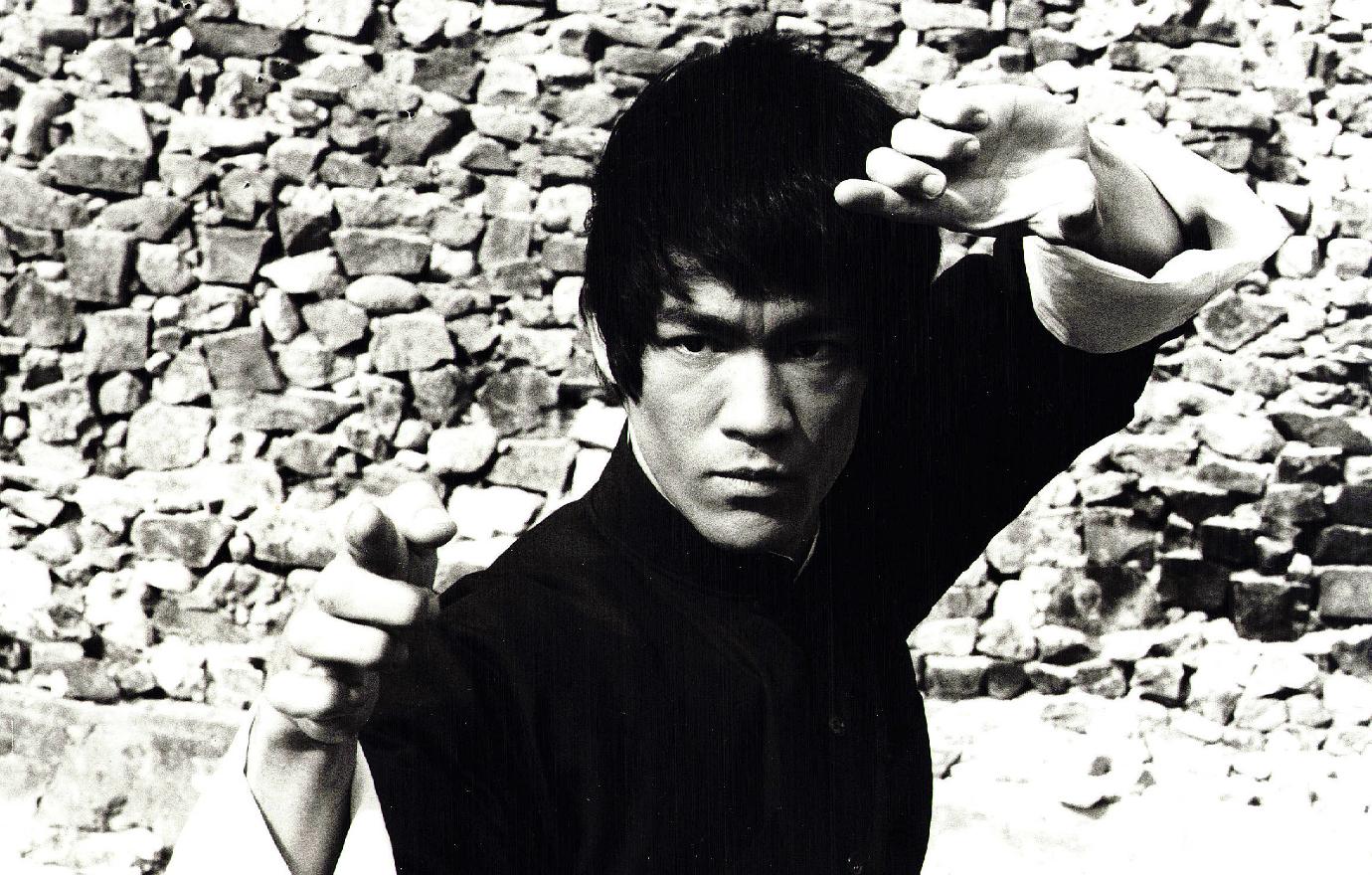 A black and white shot of Bruce Lee posing in a classic kung-fu stance.