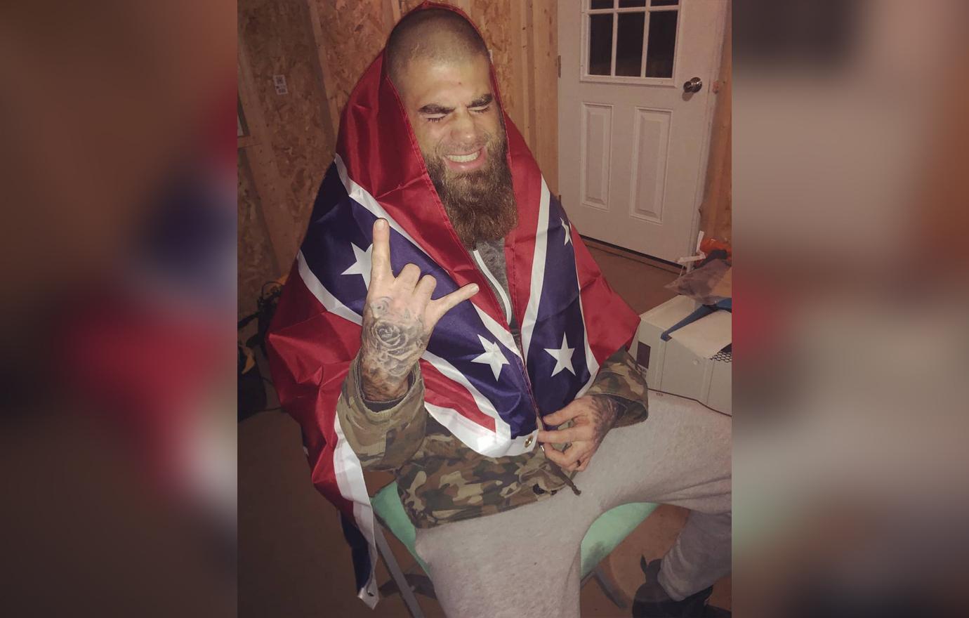 David Eason poses for a photo with the confederate flag wrapped around him.