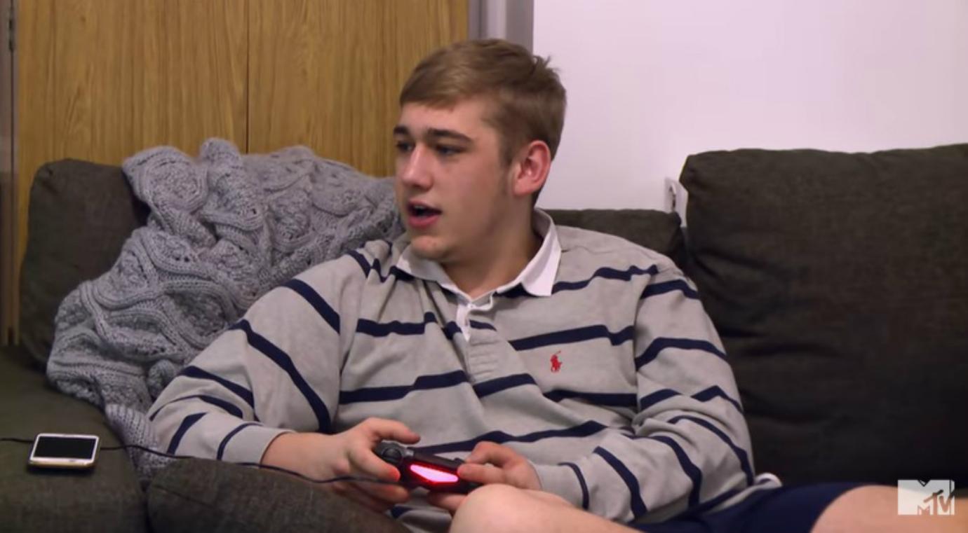 Jordan from Teen Mom UK holds a video game controller while sitting on the couch.