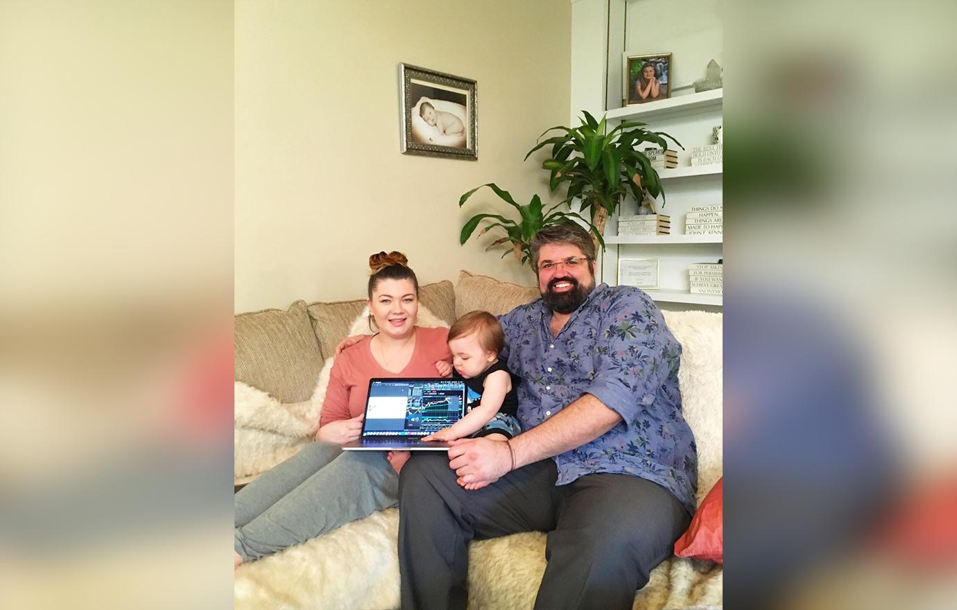 Amber Portwood Sitting With Child and Boyfriend Andrew Glennon on Couch with Laptop Smiling