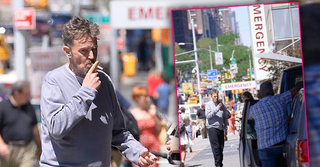 Matthew Perry Wearing Grey Top Smoking a Cigarette On A NYC Street In Font Of Hospital