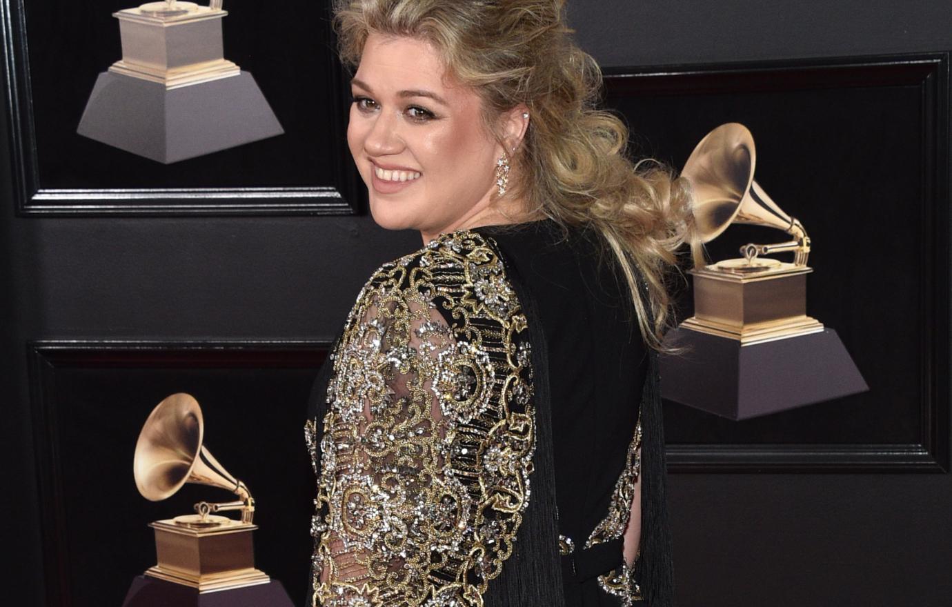 Kelly at the Grammys in a black dress with gold sleeves