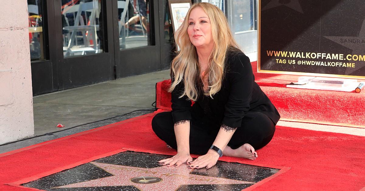 Christina Applegate sits next to her Walk of Fame star