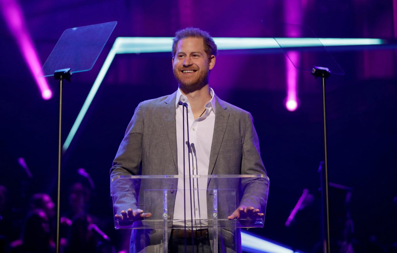 Prince Harry made a speech at Royal Albert Hall and wore a grey blazer and an off-white oxford.