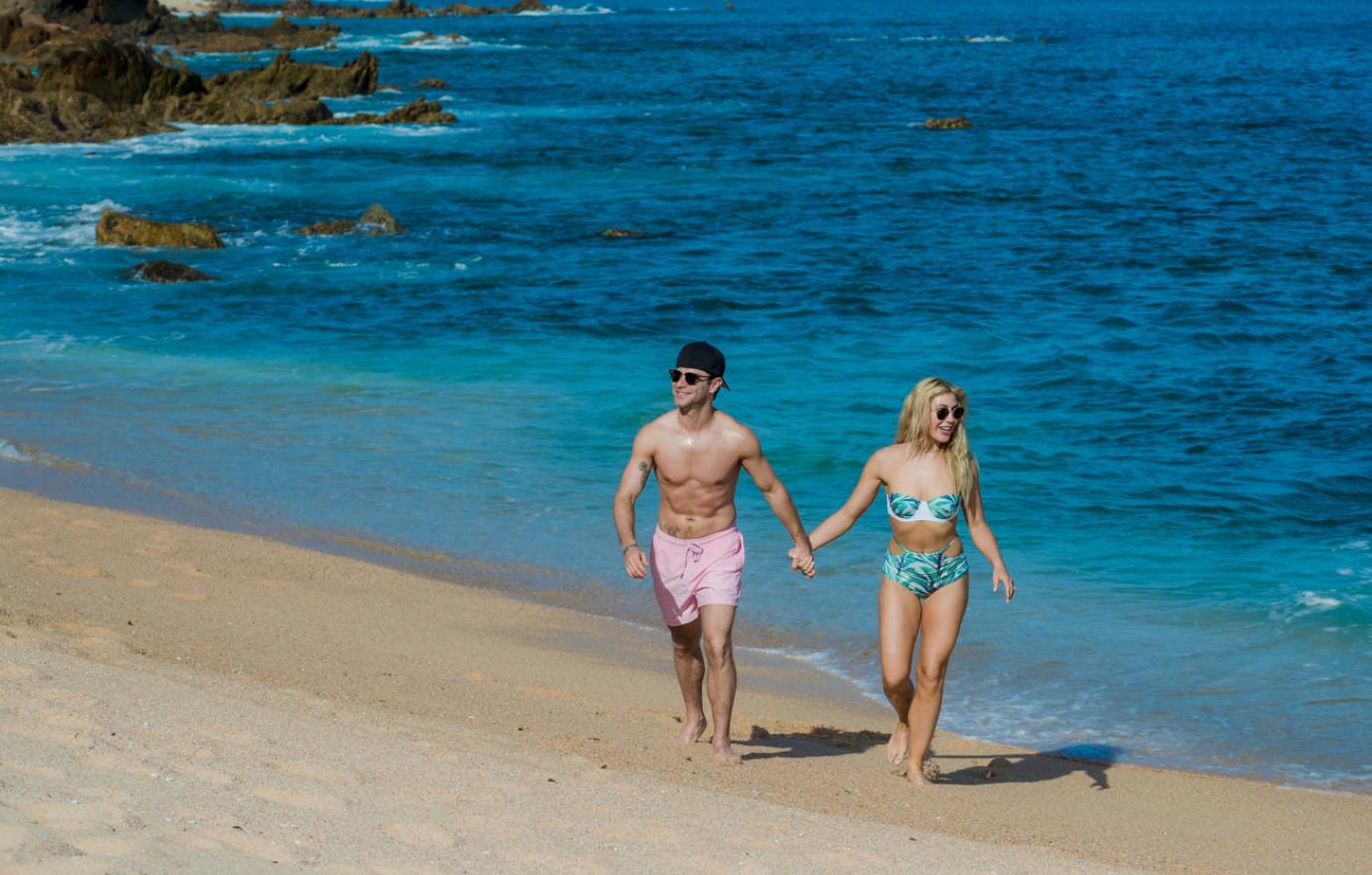 A couple walk on the beach in Los Cabos