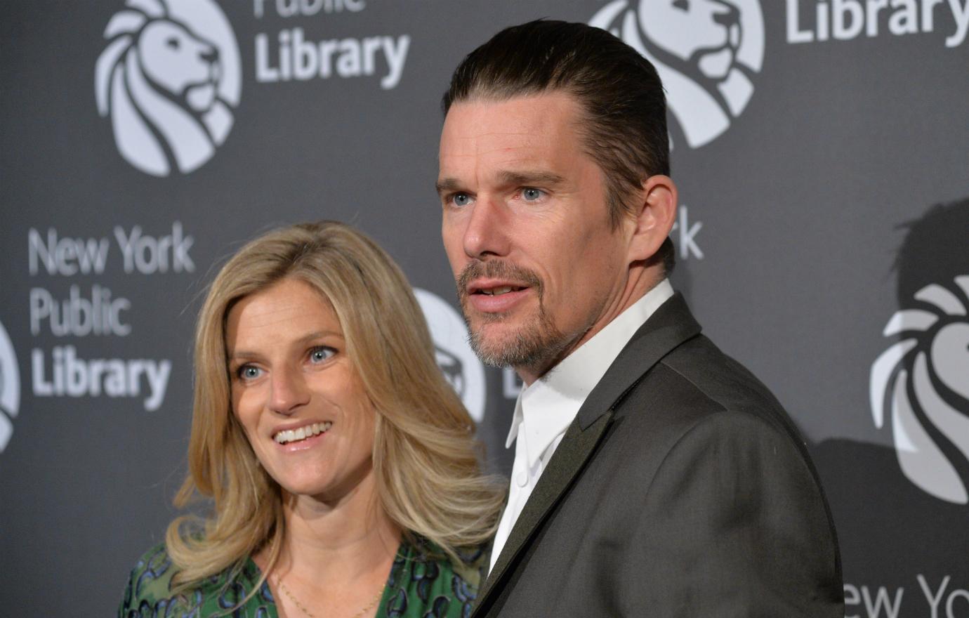 Ethan Hawke, in a dark suit, poses on the red carpet with his wife Ryan.