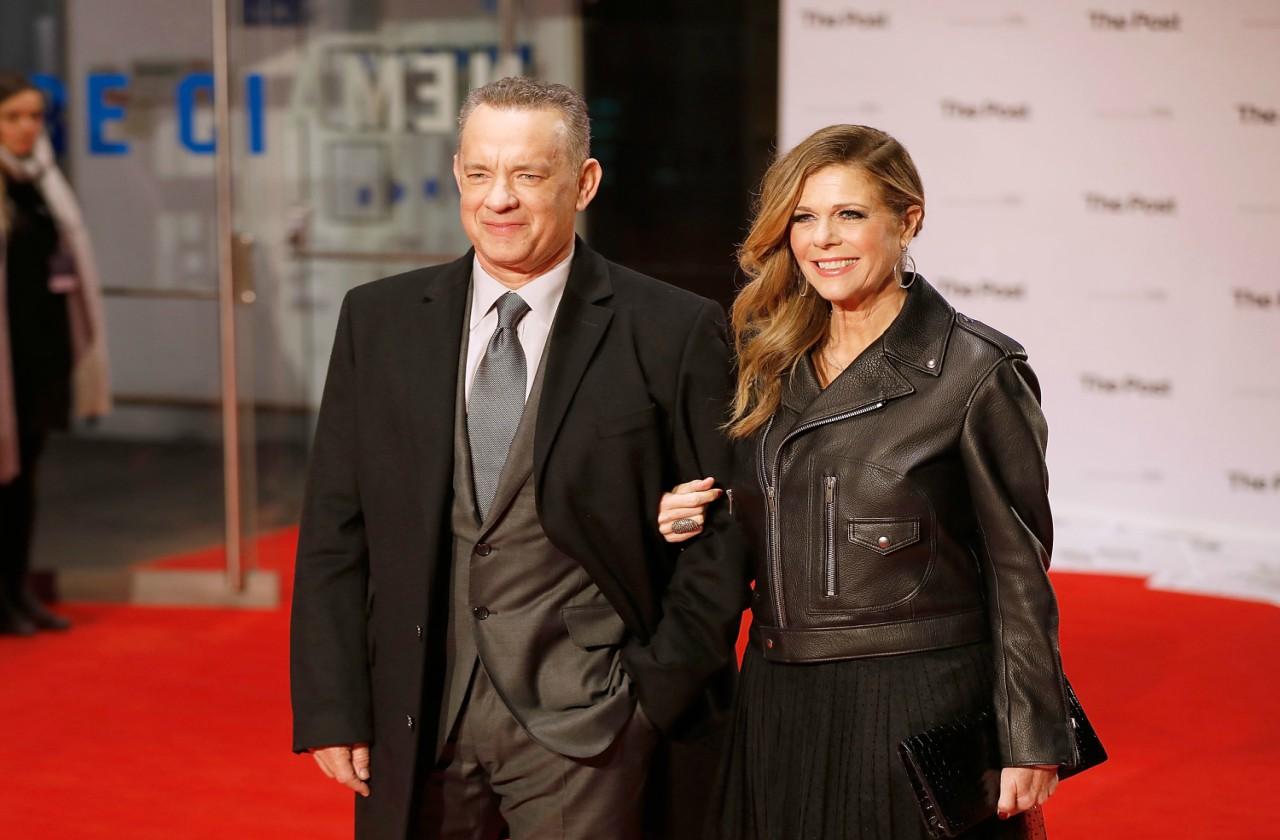 Tom Hanks and Rita Wilson, both dressed in black, pose with linked arms on the red carpet