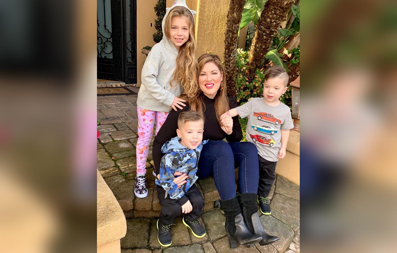 Emily Simpson Smiles and Sits On Front Steps to Home Posing With Three Children