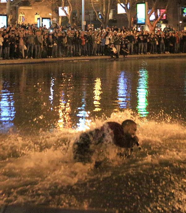 Kanye West jumps into water as fans, cops, jump in along with the soaking wet rapper at last minute concert in Armenia. Kanye decided to organize the show at literally 9pm on late Sunday night and by using social media over 3,000 screaming fans showed up at the duck pond to watch him perform at nearly 1:20am local time. Kanye was on stage singing his hit when his mic started to short out as the crowd noticed. Minutes later he asked a section of the crowd if they could see him and after realizing they could not, he jumped literally into the middle of the duck pond and drops his mic into the water due to it being too wet and ruined. He is then literally surrounded by the fans as they run into the water with him as his bodyguard Pascal is spotted running to his side along with the Armenian National Guard and Police all getting soaking wet to retrieve the rap star. Kanye was then brought closer as a fan tried to touch his hand, the cops pushed him and Kanye reacted to holding the cops back to let the fan get a photo with him in the pond too! Madness occurs in a stampede style follow as Kanye is finally pulled to the top of the pond and is guided with his entourage out of the park with thousands running and following him out of the concert. Kim Kardashian was shown on side stage watching her man perform and was all smiles