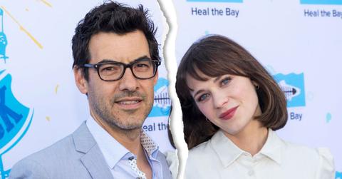 Jacob Pechenik Wearing Glasses, Blue Shirt And Suit With Zooey Deschanel Wearing White Blouse Standing In Front Of SAVE THE BAY Step And Repeat
