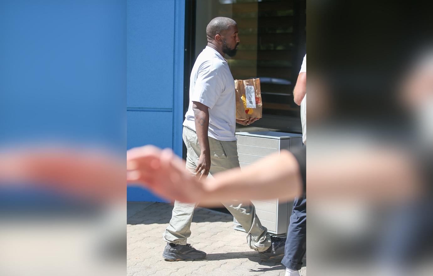 Kanye West carries a bag of fast food from his beloved McDonalds as he heads to a meeting in Calabasas.