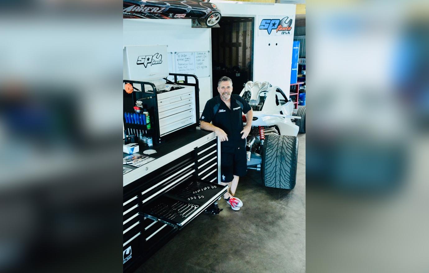 ToyMakerz David Ankin Poses Smiling Inside Garage Next to Modified Vehicle