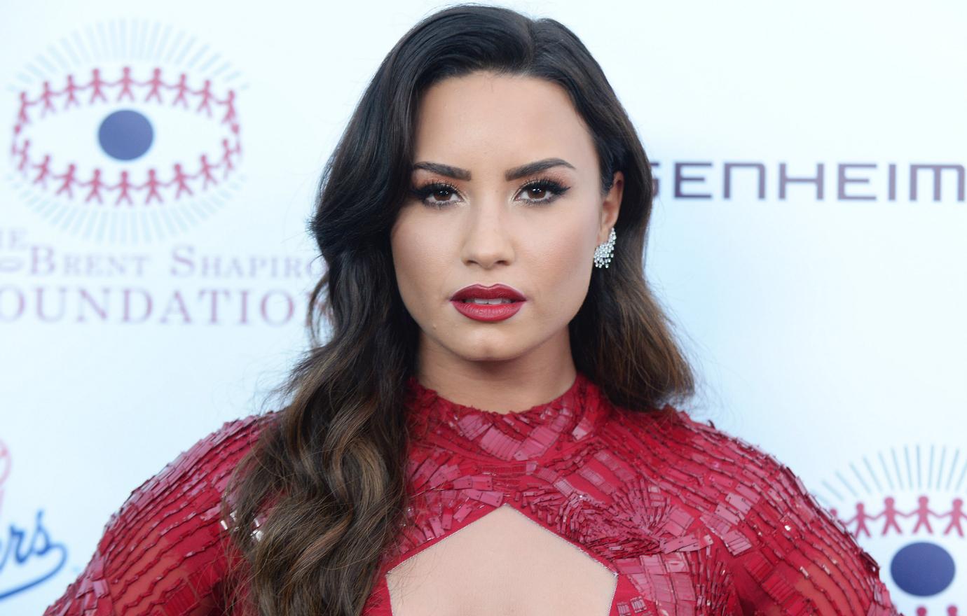 Demi Lovato stunned in a red lacy cleavage exposing gown.