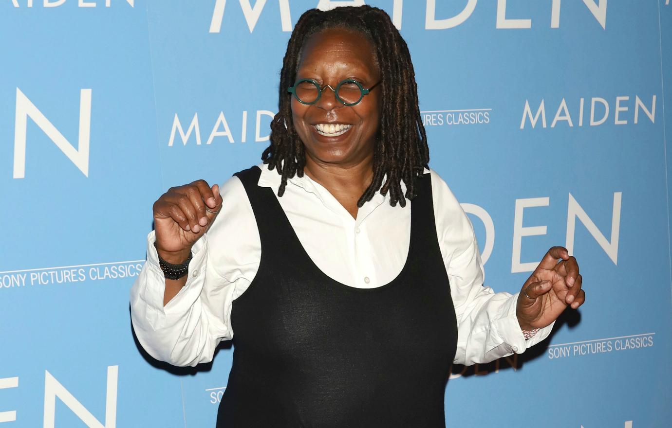 Whoopi Goldberg walked a red carpet in black dress with a white oxford shirt underneath..