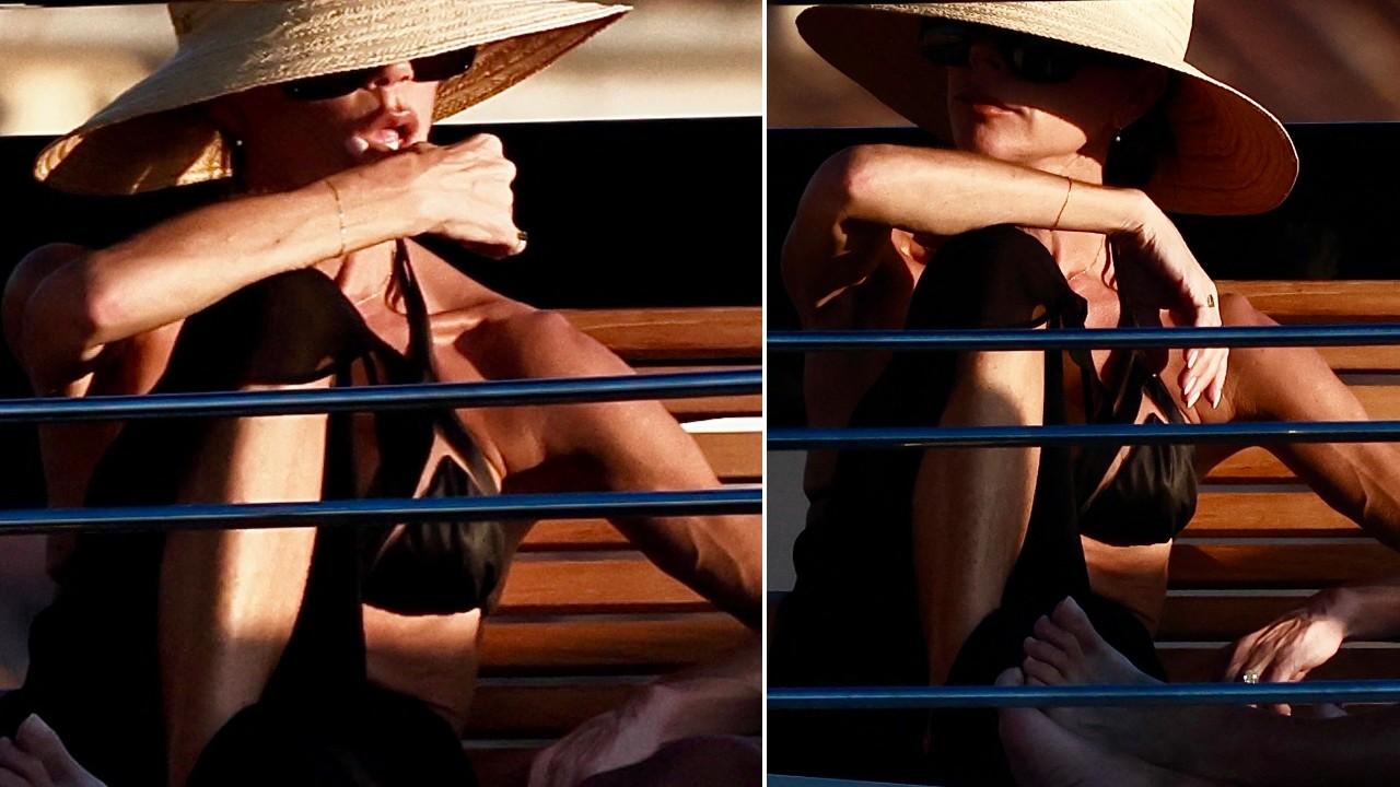 Victoria Beckham accessorized her beach attire with a hat and sunglasses.