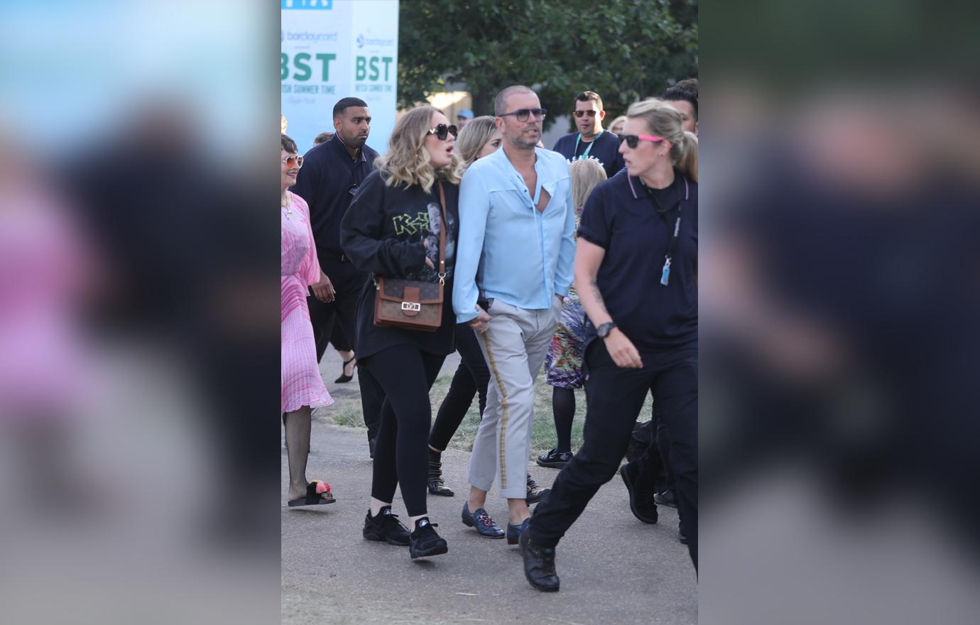 Adele is seen surrounded by bodyguards while holding hands with a male friend in Hyde Park, London, where Celine Dion was headlining.