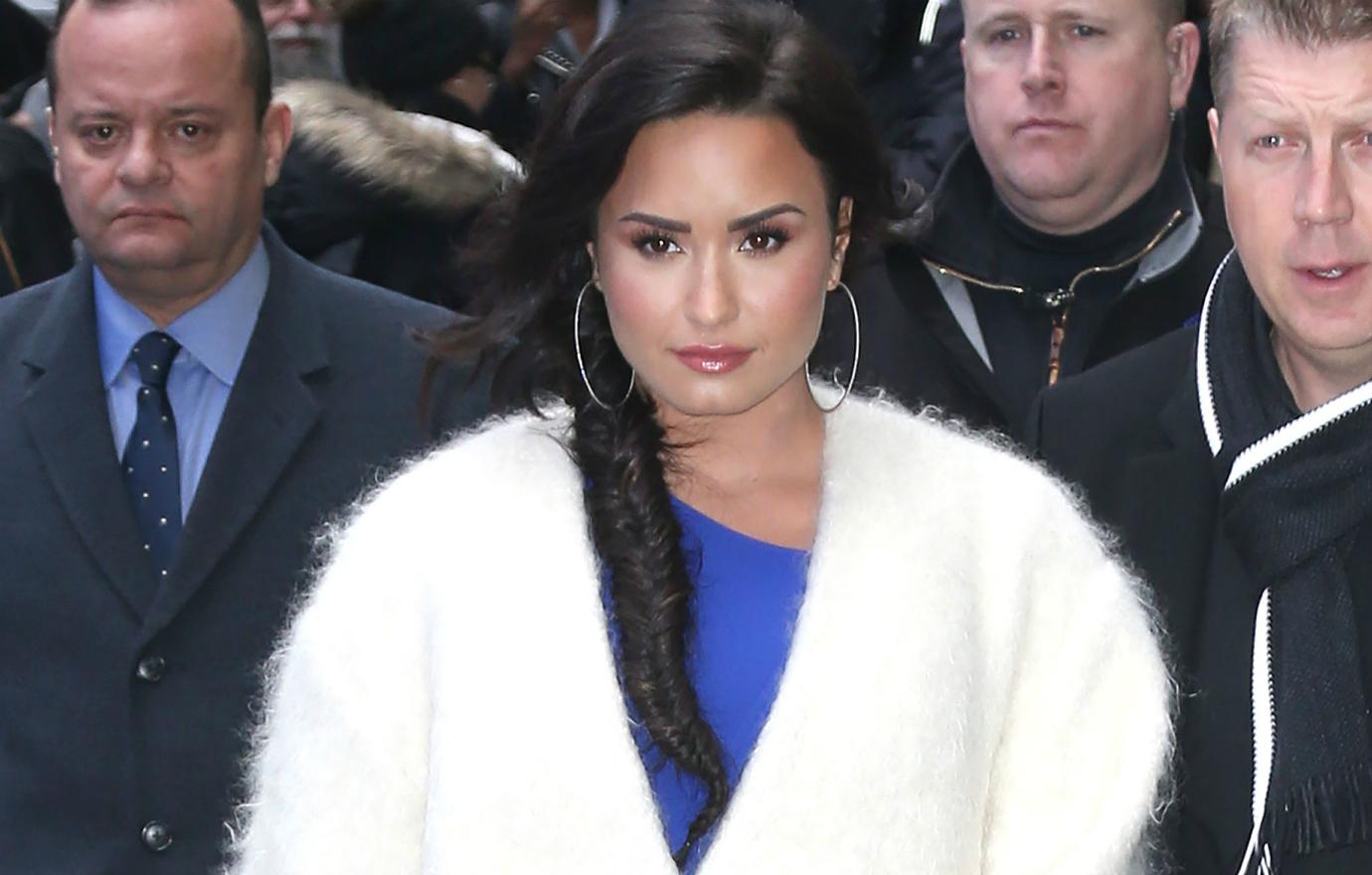 Demi Lovato appeared at Good Morning America in a white ankle length faux fur coat that covered a blue top.