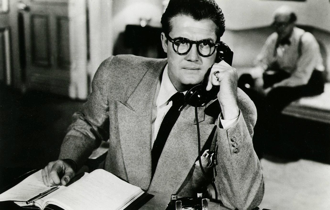 Black and white still of George Reeves on the phone from the Superman TV show.