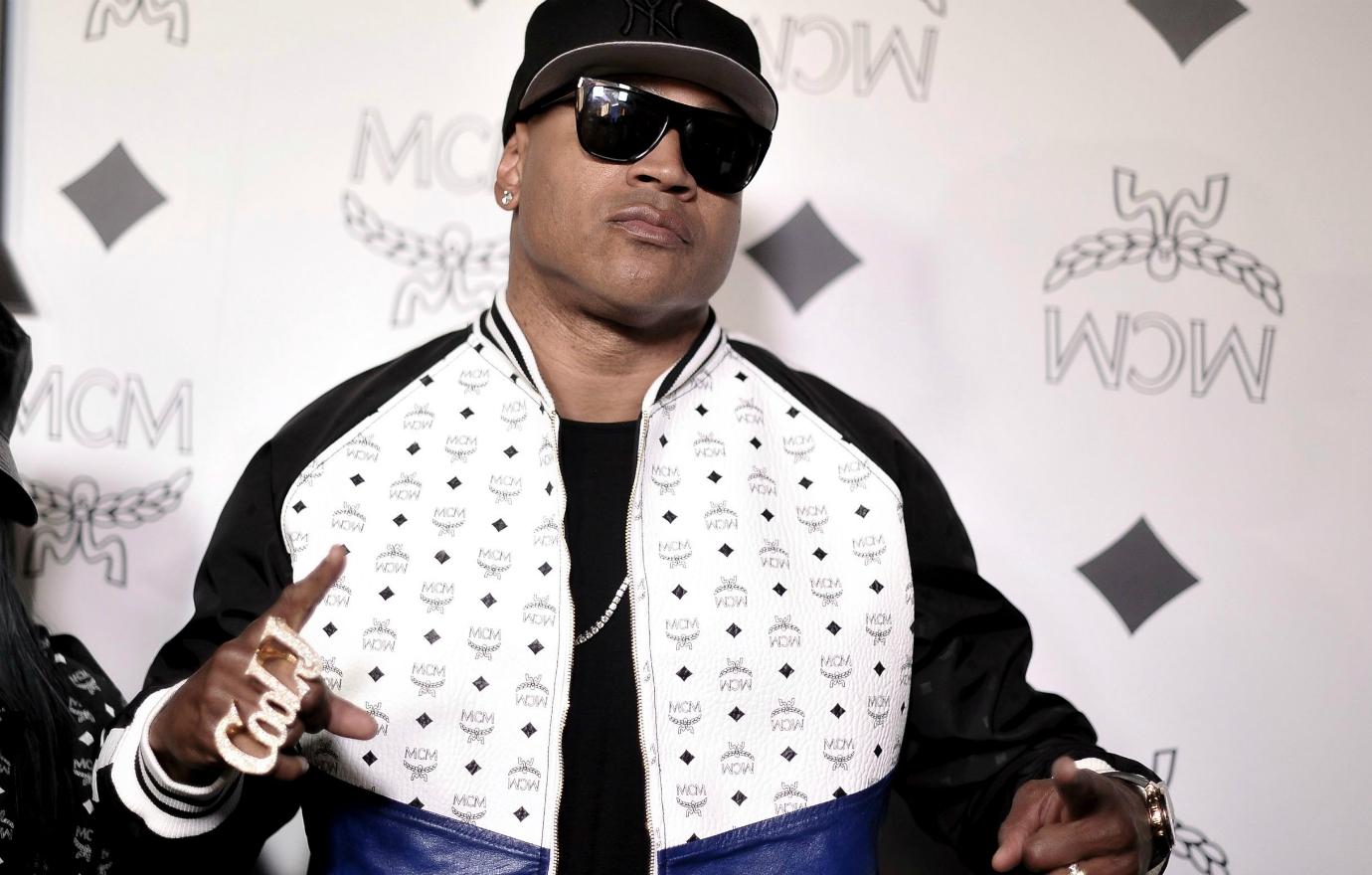 LL Cool J wore a white zipped up jacket with a black T-shirt underneath, a black Yankees baseball hat and tinted glasses.