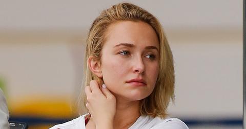 Closeup of Hayden panettiere In Ripped White T-Shirt Touching Her Neck And Looking Concerned