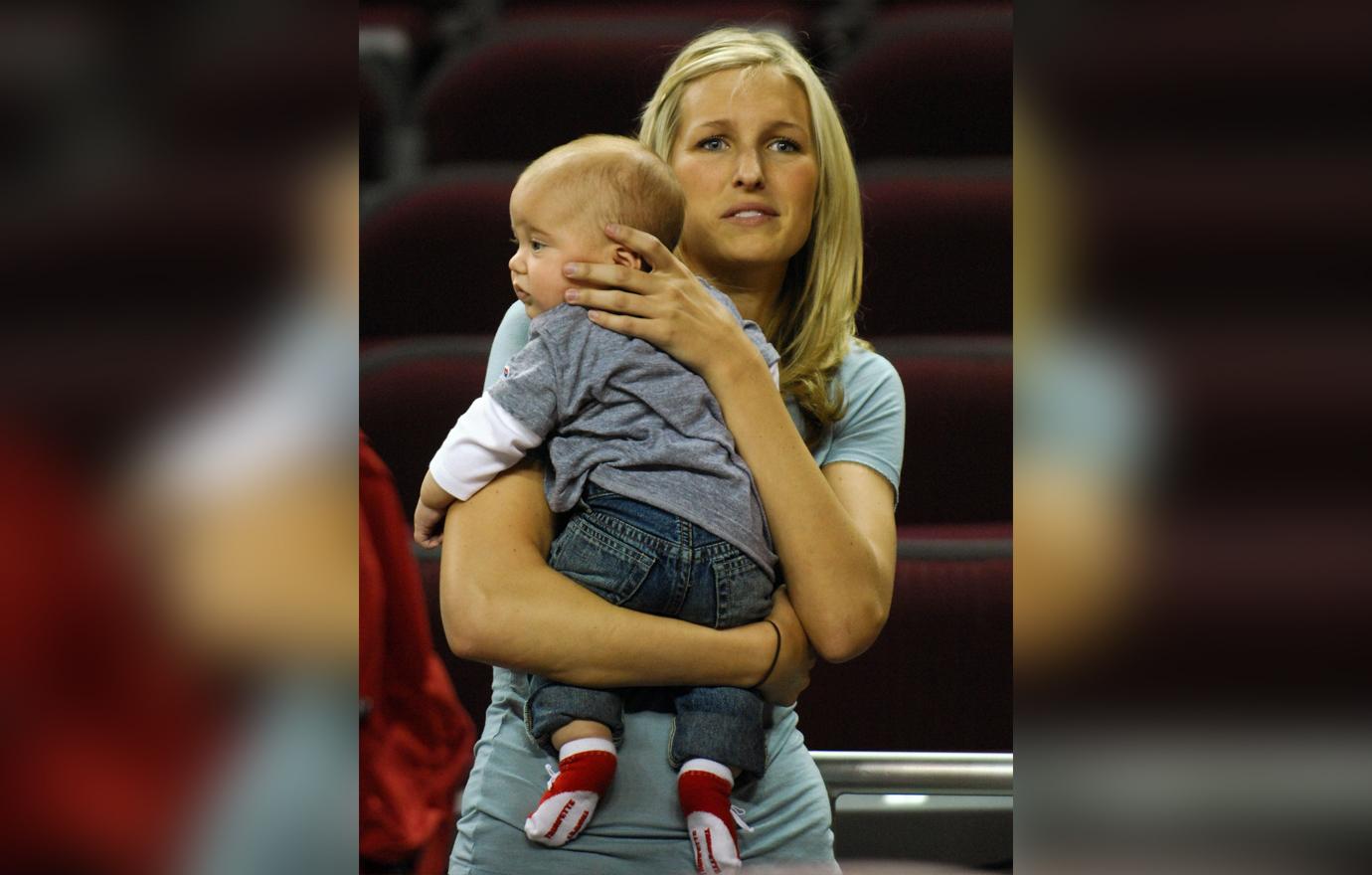 Brynn Cameron wears a grey sweater while holding her son.