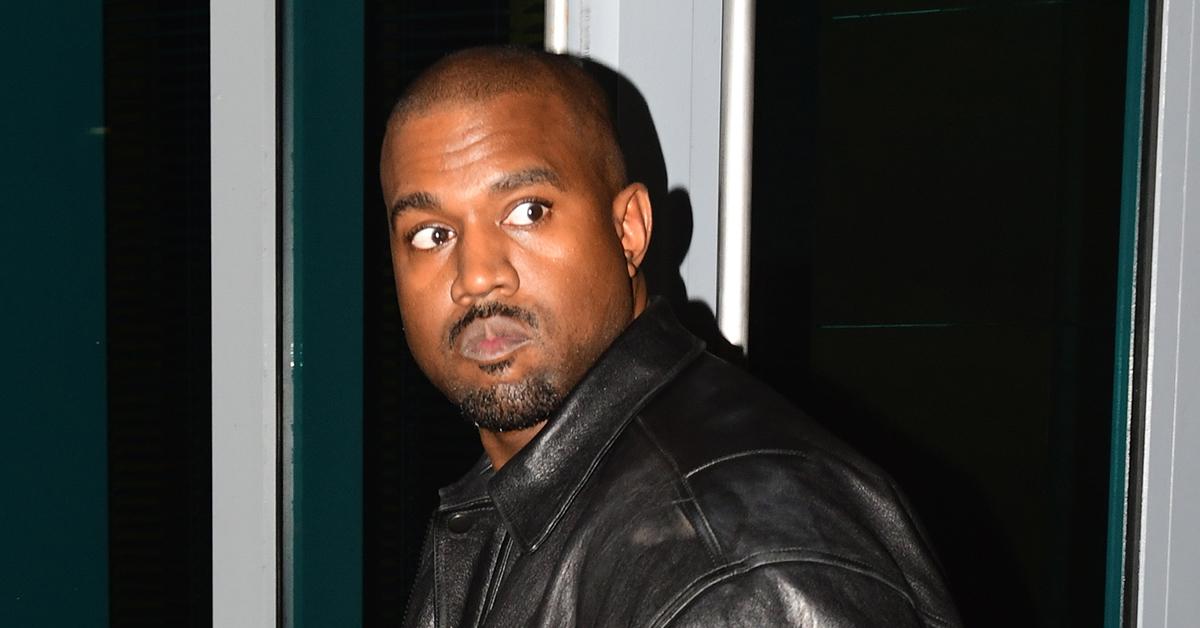 Kanye West leaving his office in a red and blue checkered jacket