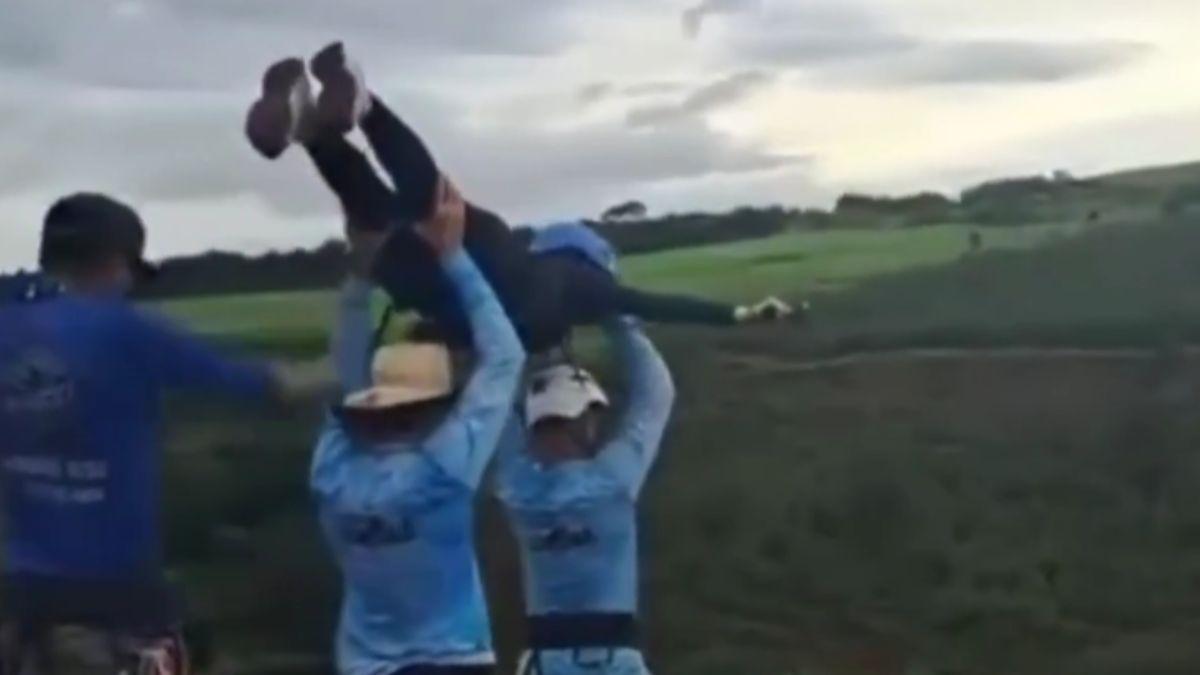 Video of the incident shows workers hoisting the woman over their heads and tossing her 'airplane style'.