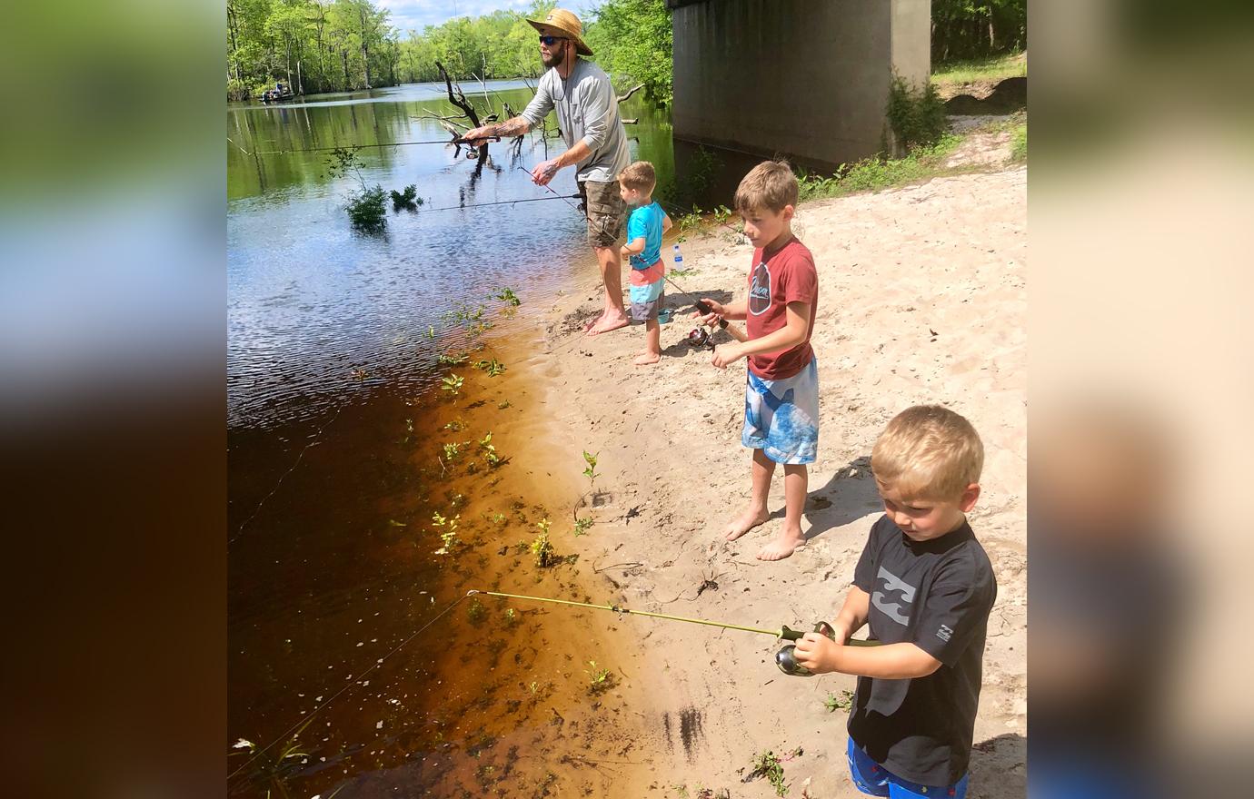 David Eason fishing with his children.