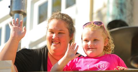 Honey Boo Boo Alana Thompson and Mama June wave at The Grove in this 2012 image, with Alan wearing a pink t-shirt and her mom wearing a black cardigan.