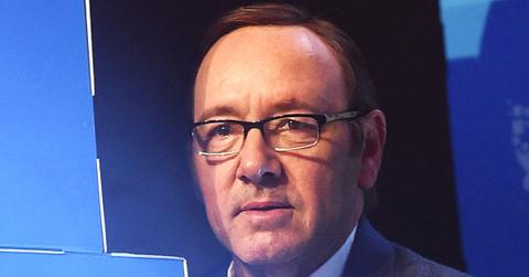 Kevin Spacey With Glasses, White Shirt and Grey Jacket With Blue Background