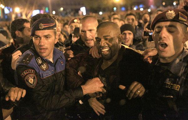 Kanye West jumps into water as fans, cops, jump in along with the soaking wet rapper at last minute concert in Armenia. Kanye decided to organize the show at literally 9pm on late Sunday night and by using social media over 3,000 screaming fans showed up at the duck pond to watch him perform at nearly 1:20am local time. Kanye was on stage singing his hit when his mic started to short out as the crowd noticed. Minutes later he asked a section of the crowd if they could see him and after realizing they could not, he jumped literally into the middle of the duck pond and drops his mic into the water due to it being too wet and ruined. He is then literally surrounded by the fans as they run into the water with him as his bodyguard Pascal is spotted running to his side along with the Armenian National Guard and Police all getting soaking wet to retrieve the rap star. Kanye was then brought closer as a fan tried to touch his hand, the cops pushed him and Kanye reacted to holding the cops back to let the fan get a photo with him in the pond too! Madness occurs in a stampede style follow as Kanye is finally pulled to the top of the pond and is guided with his entourage out of the park with thousands running and following him out of the concert. Kim Kardashian was shown on side stage watching her man perform and was all smiles