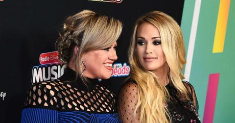 Carrie Underwood and Kelly Clarkson stand next to each other on the red carpet.