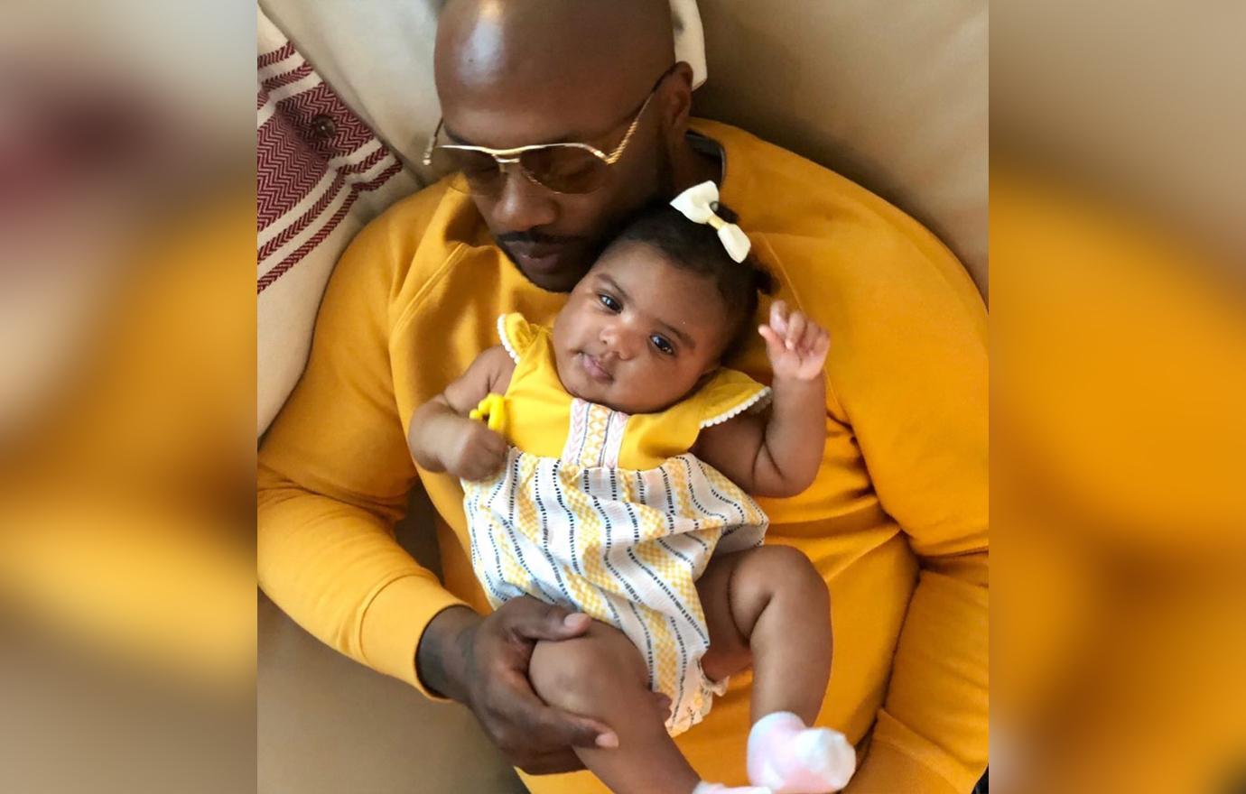 Dennis McKinley in Yellow Sweater Holds Baby Pilar