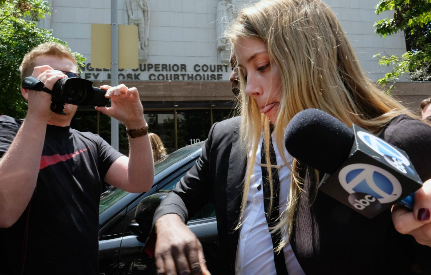 Amber Heard left court in a black blazer as paparazzi swarmed.