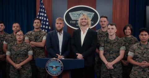 A photo of Jake and Logan Paul with servicemen and women