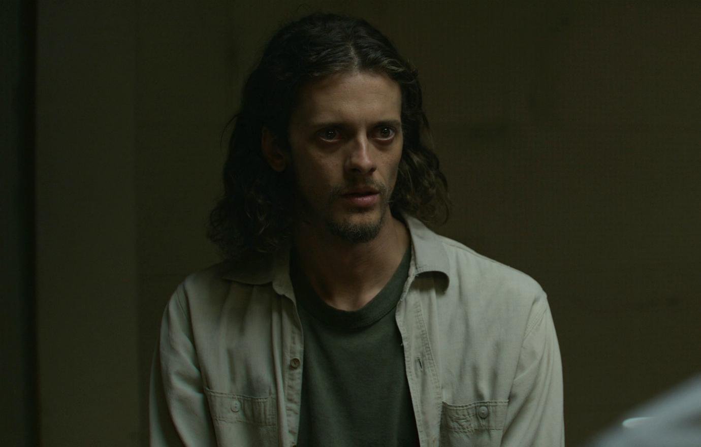 Actor Adam Zastrow wore a green T-shirt with a denim flannel over it in a scene from Mindhunter on Netflix.