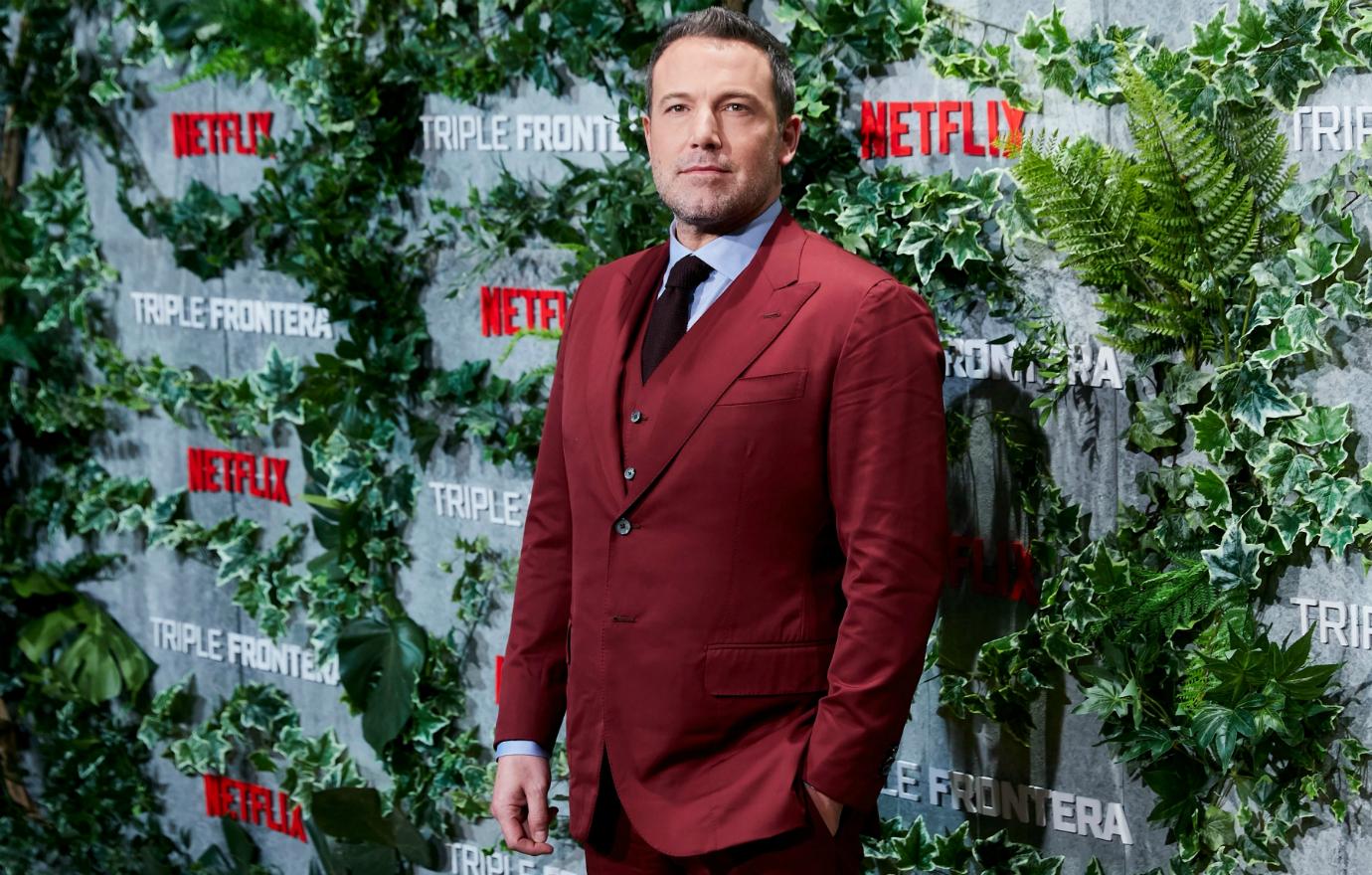 Ben Affleck dazzled in a dark maroon suit, accessorized with a black tie, at a film premiere.