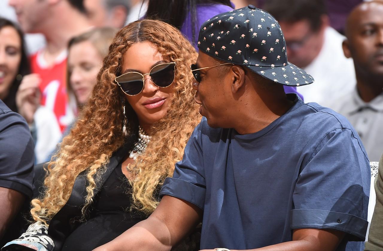 Beyonce and Jay-Z enjoy a game together, disguised in sunglasses